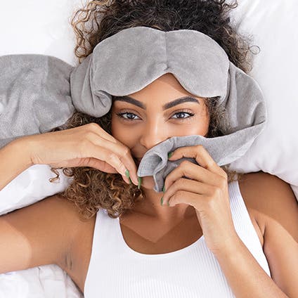 A woman with a lightly weighted fleece sleep mask.