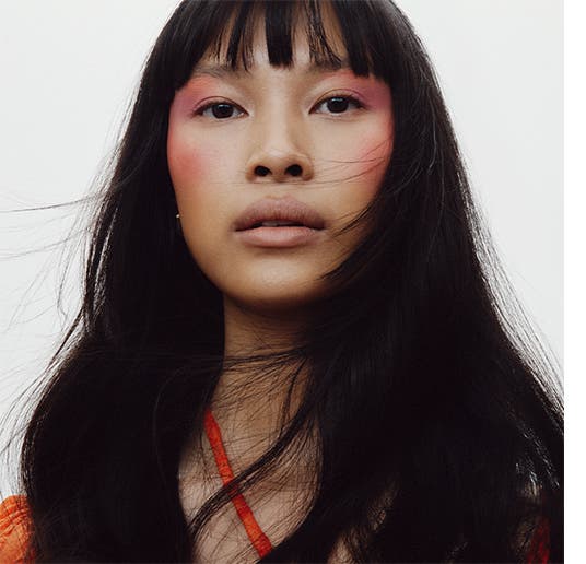 A woman model with bright cheek and eye makeup.