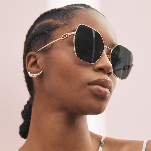 A woman wearing oversized square sunglasses.