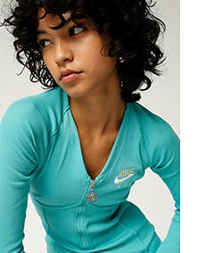 Woman wearing a turquoise active dress from Nike.