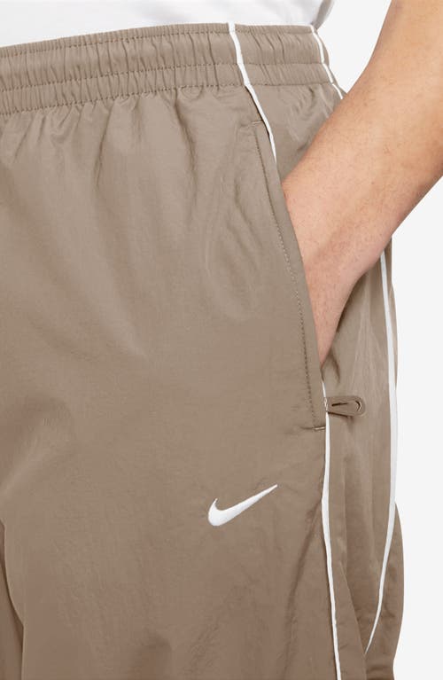 Shop Nike Solo Swoosh Water Repellent Track Pants In Khaki/white