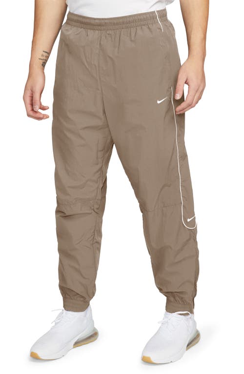 Shop Nike Solo Swoosh Water Repellent Track Pants In Khaki/white