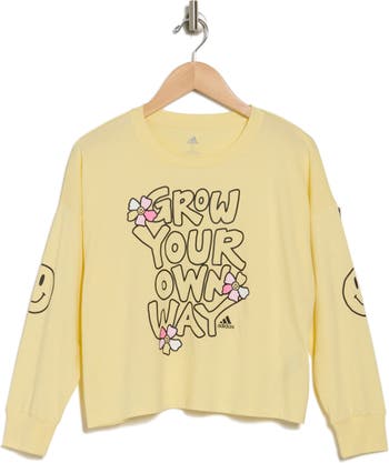 A yellow sweater with a slogan and flowers on it