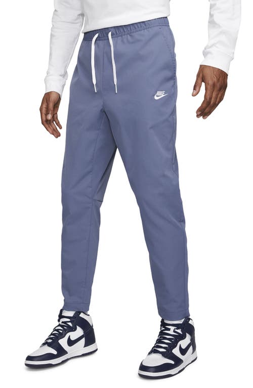 Shop Nike Woven Tapered Leg Pants In Diffused Blue/white