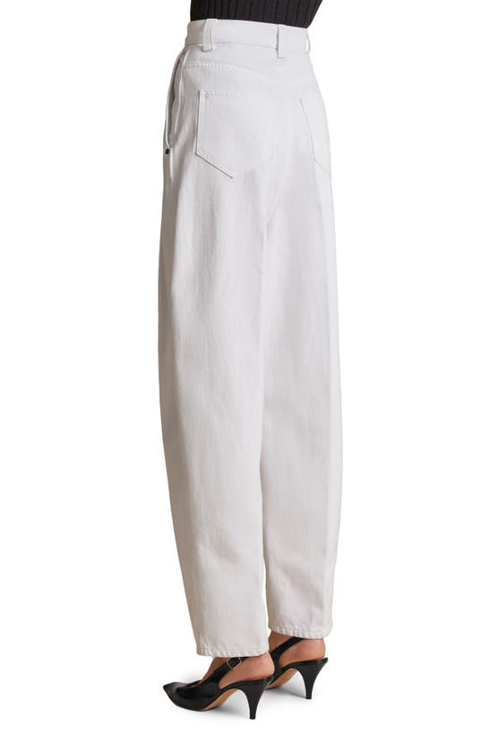 Shop Khaite The Ashford Pleated Tapered Jeans In White