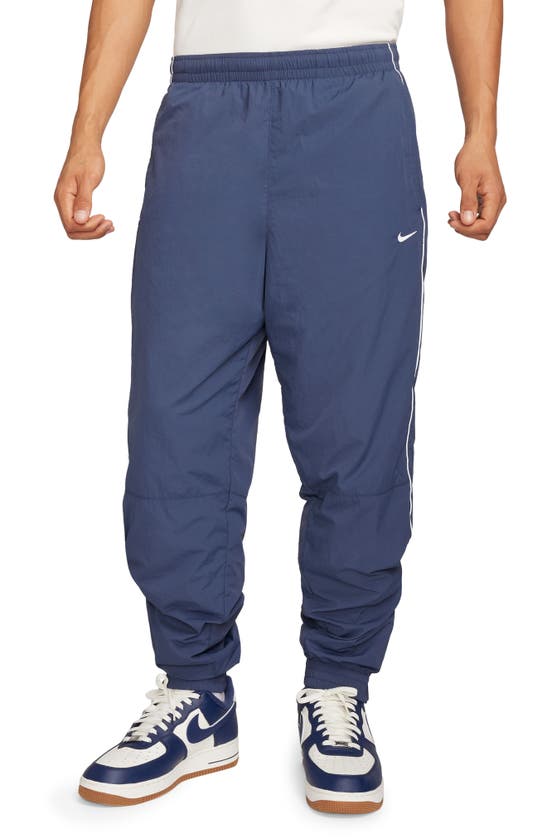 NIKE SOLO SWOOSH WATER REPELLENT TRACK PANTS