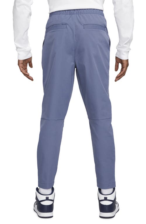 Shop Nike Woven Tapered Leg Pants In Diffused Blue/white