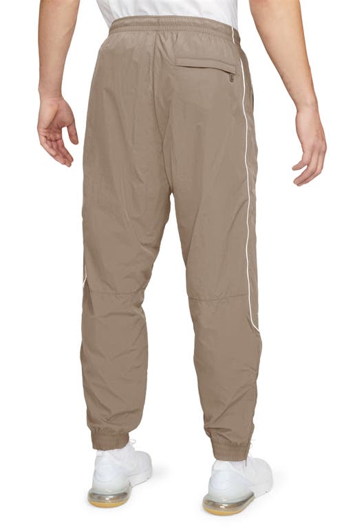 Shop Nike Solo Swoosh Water Repellent Track Pants In Khaki/white