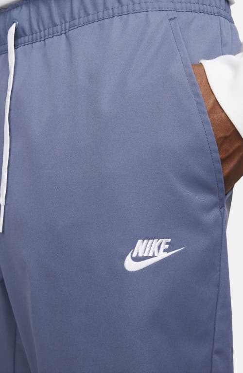 Shop Nike Woven Tapered Leg Pants In Diffused Blue/white