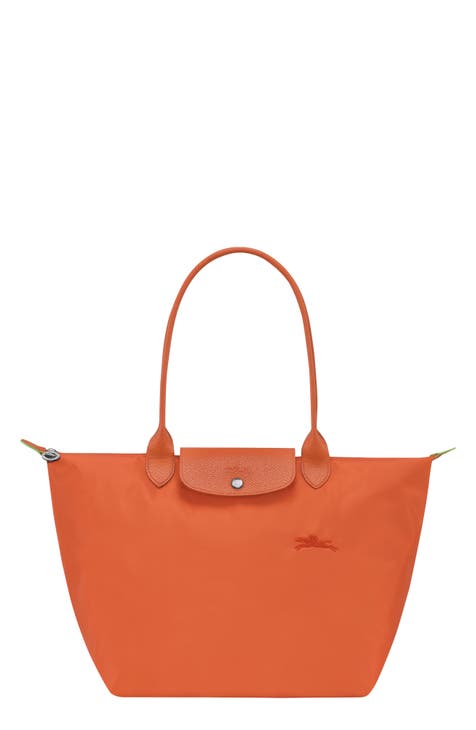 Red and orange canvas and brown leather tote with yellow hardware
