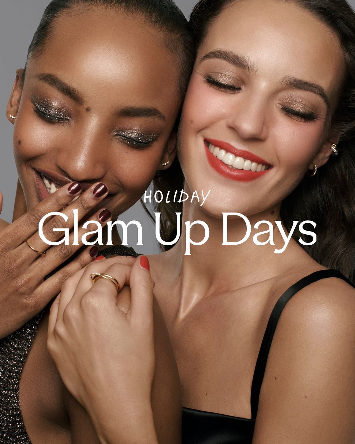 Holiday Glam Up Days; two women in glam makeup and jewelry laughing together.