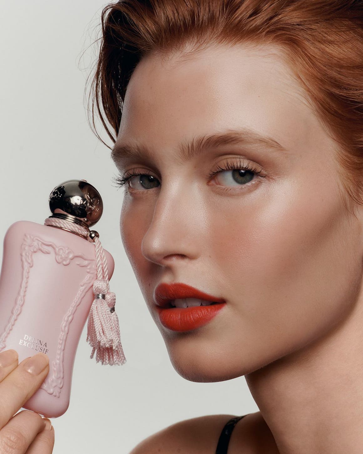 a woman holding perfume.