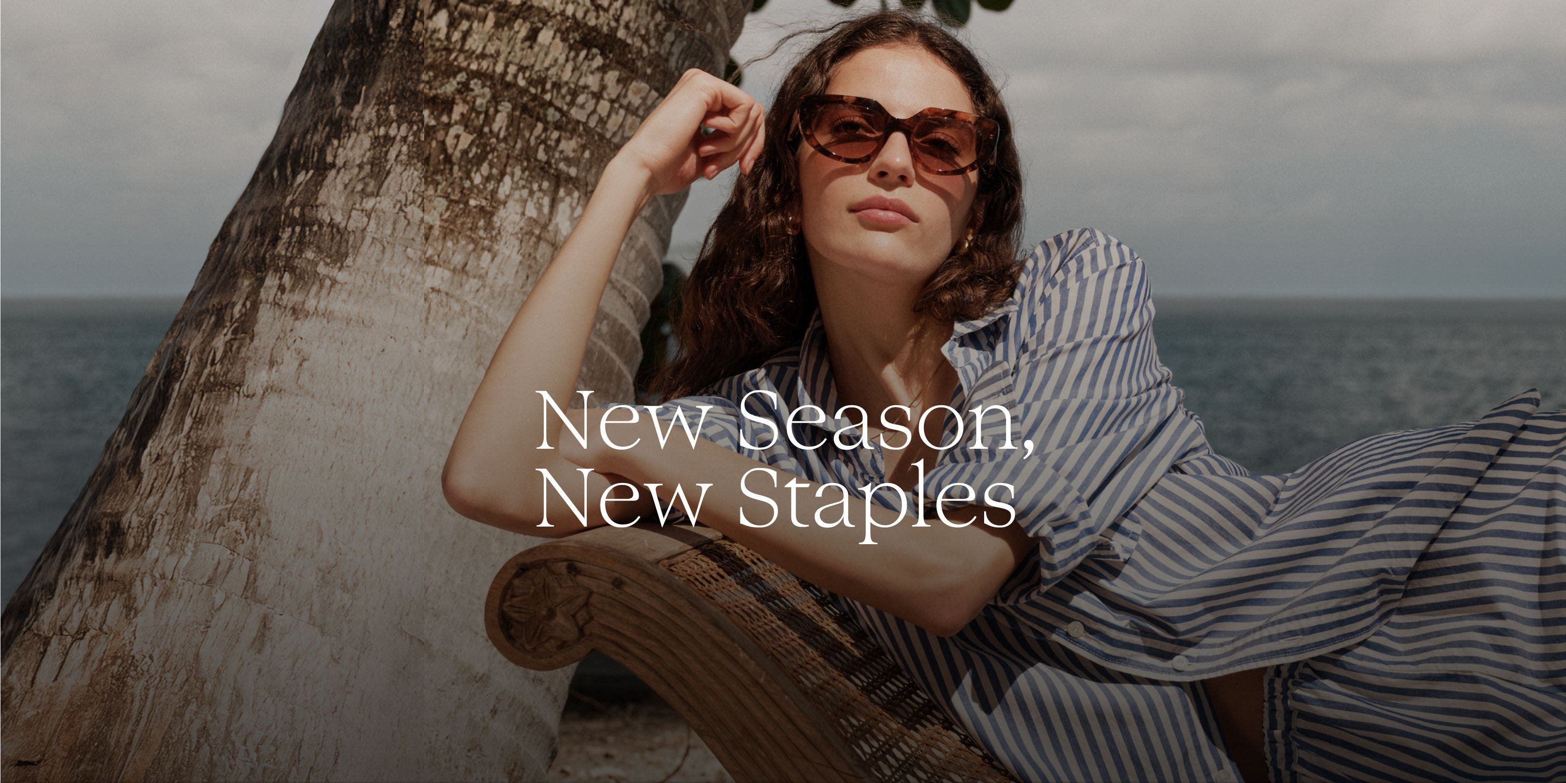 New Season, New Staples. Woman in a striped outfit and sunglasses at the beach.
