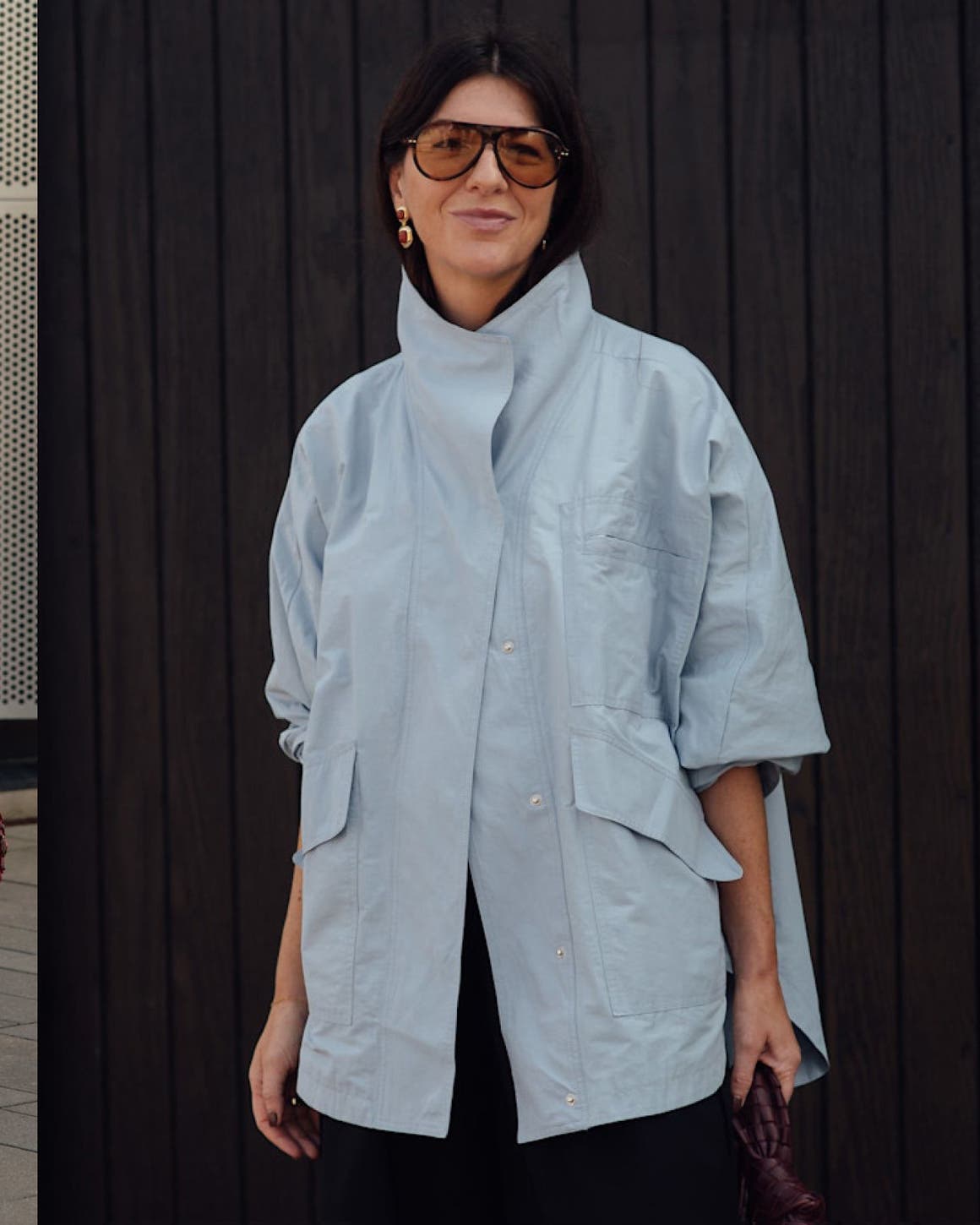 Three street-style looks: a woman in an oversized striped blue shirt and grey trousers; a woman in a light blue oversized jacket; a woman in a black embellished midi dress.