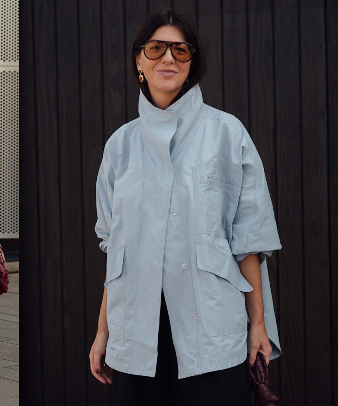 Three street-style looks: a woman in an oversized striped blue shirt and grey trousers; a woman in a light blue oversized jacket; a woman in a black embellished midi dress.