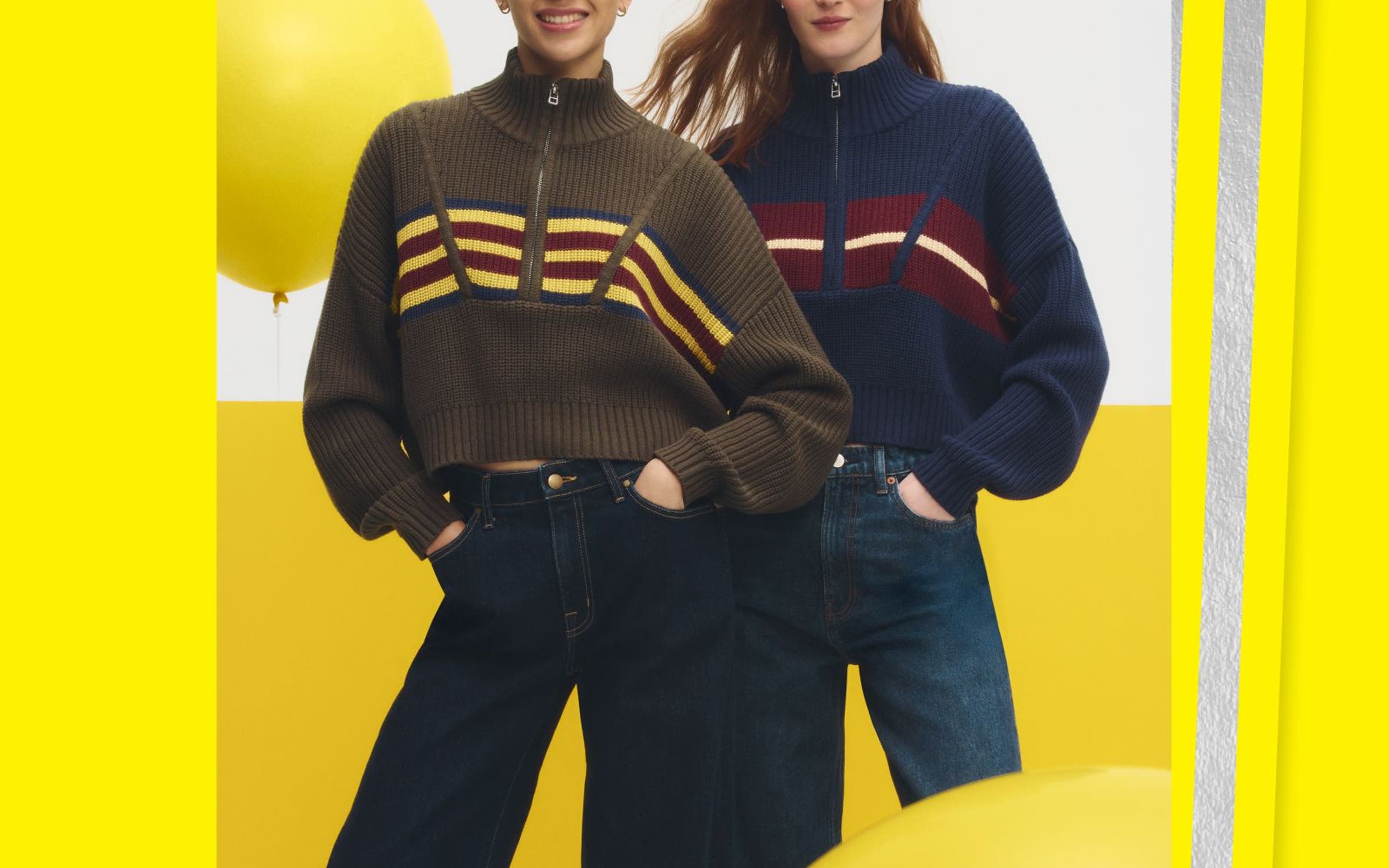 Two women wearing matching sweaters and jeans.