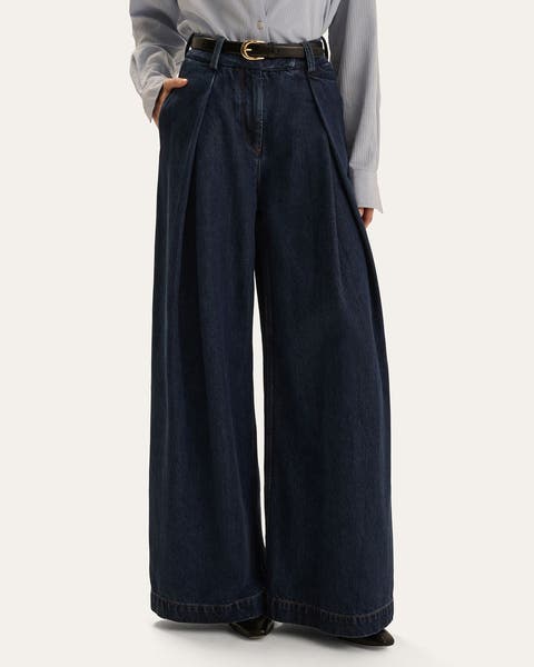 A woman wearing a pair of wide-leg dark wash denim.