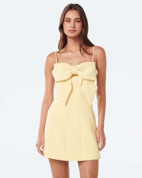 A woman wearing a semi-formal butter yellow mini dress.
