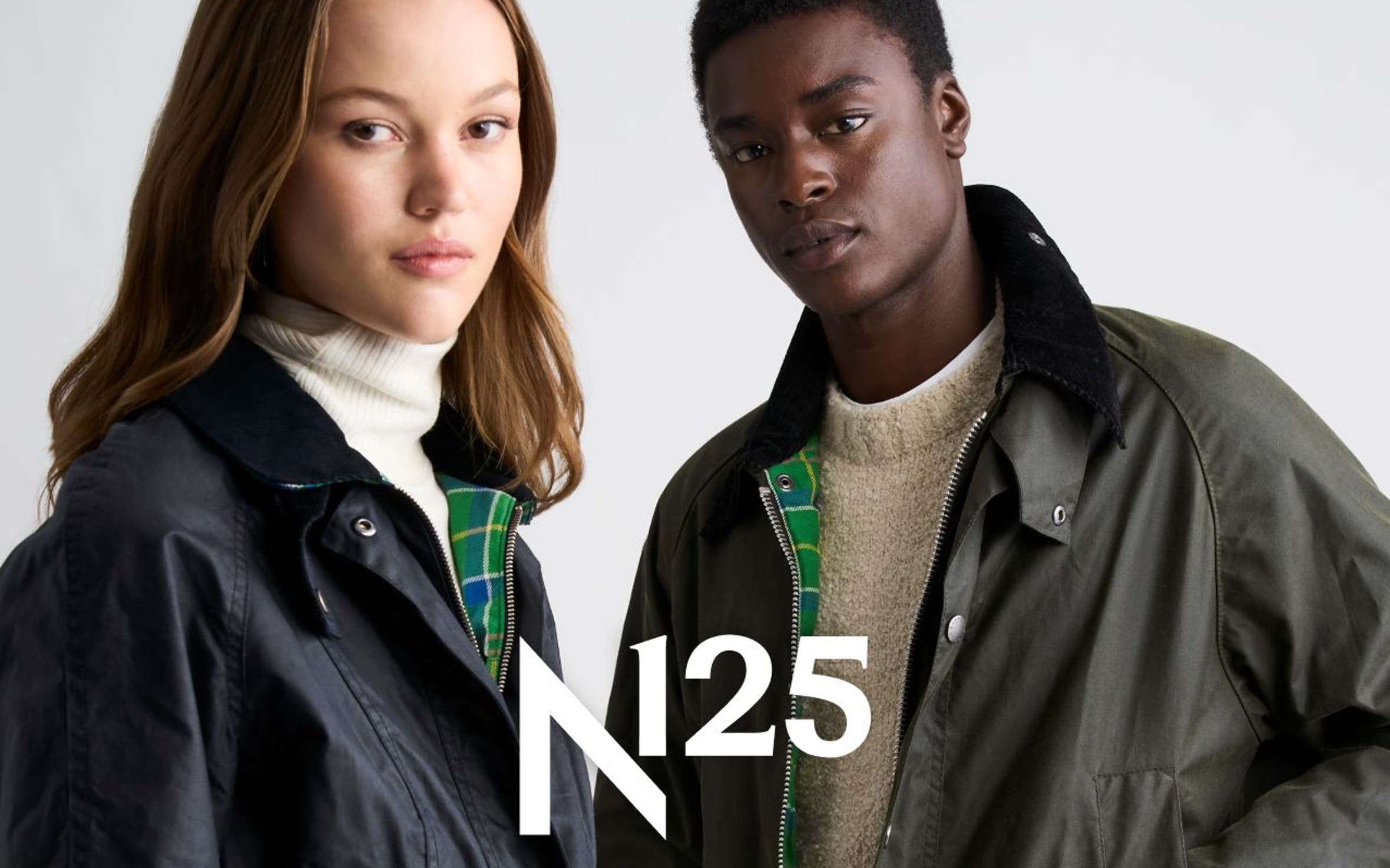 A woman and man in waxed field jackets, with an N125 logo overlay.