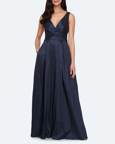 A woman wearing a navy blue v-neck gown.