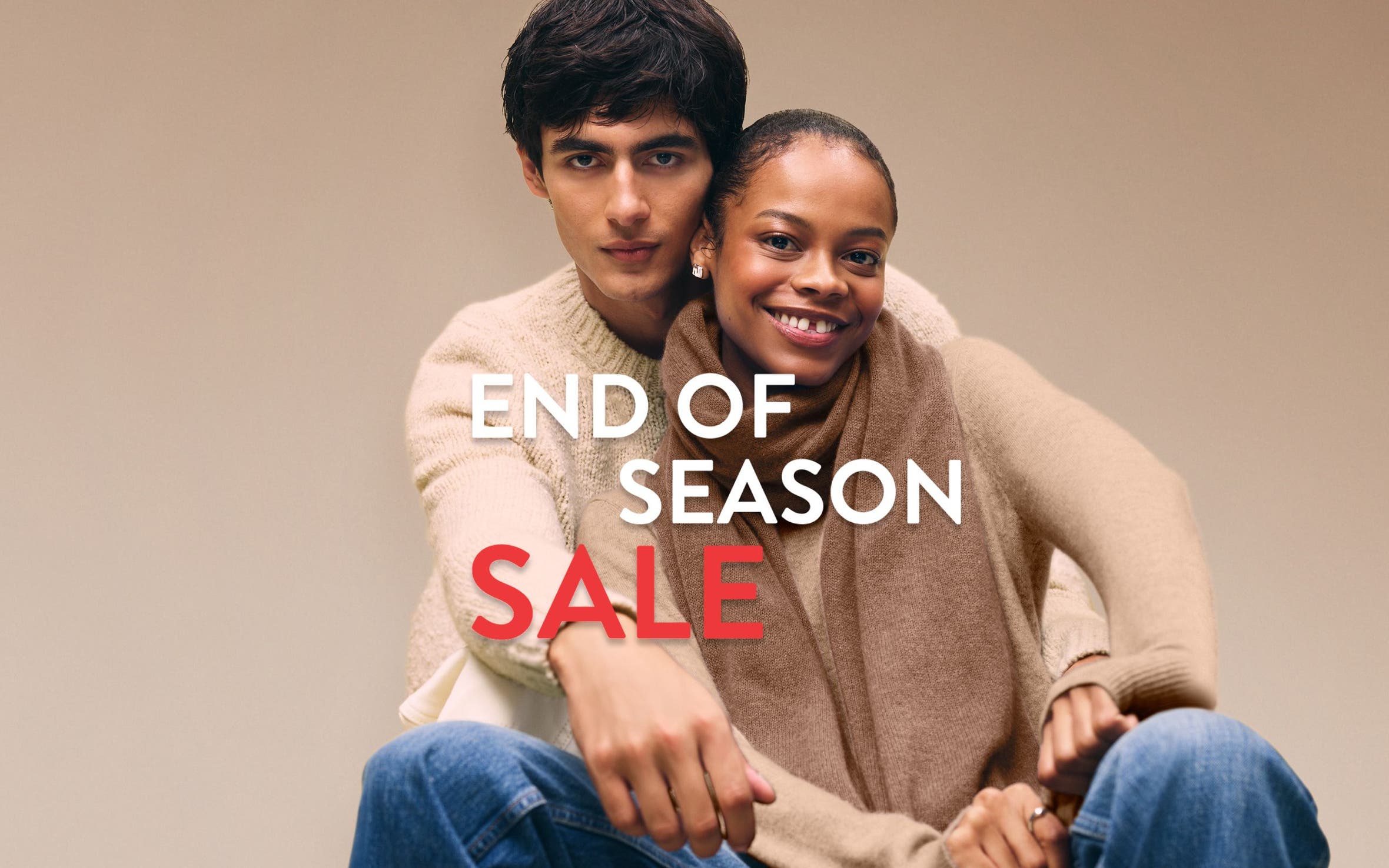 End-of-season sale. A woman and man wearing cozy knitwear.