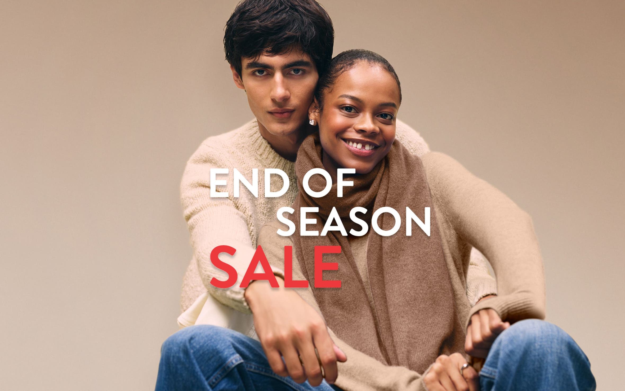 End-of-season sale. A woman and man wearing cozy knitwear.
