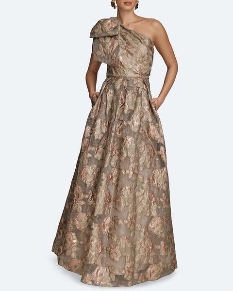 A woman wearing a champagne-colored big bow one shoulder gown.
