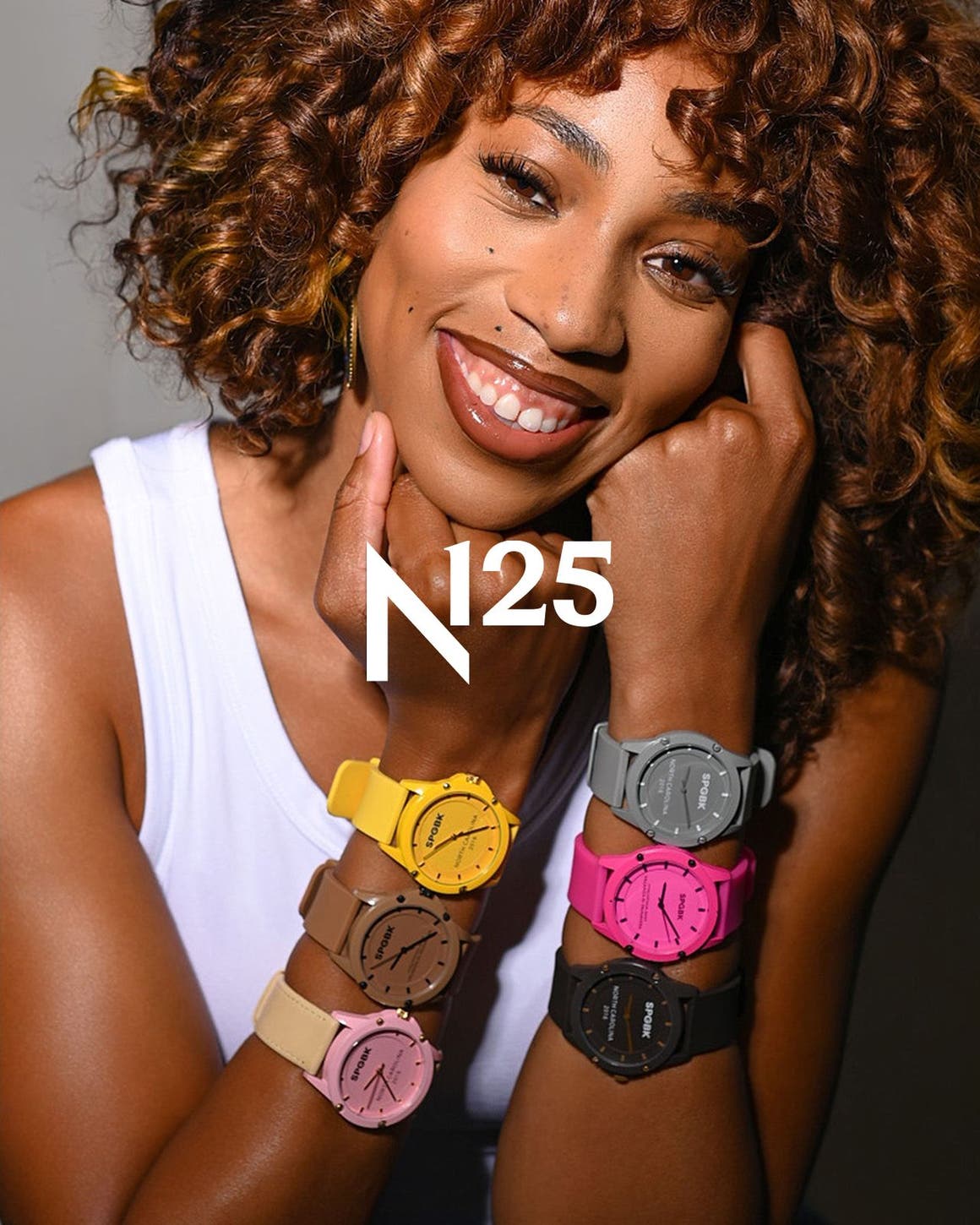 A woman wearing multiple SPGBK watches on both wrists, in a range of colorways.