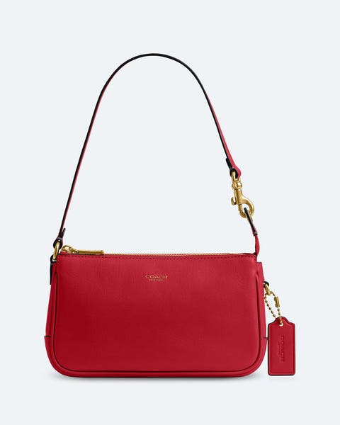 Red leather Coach mini shoulder bag with gold-tone hardware and adjustable strap.