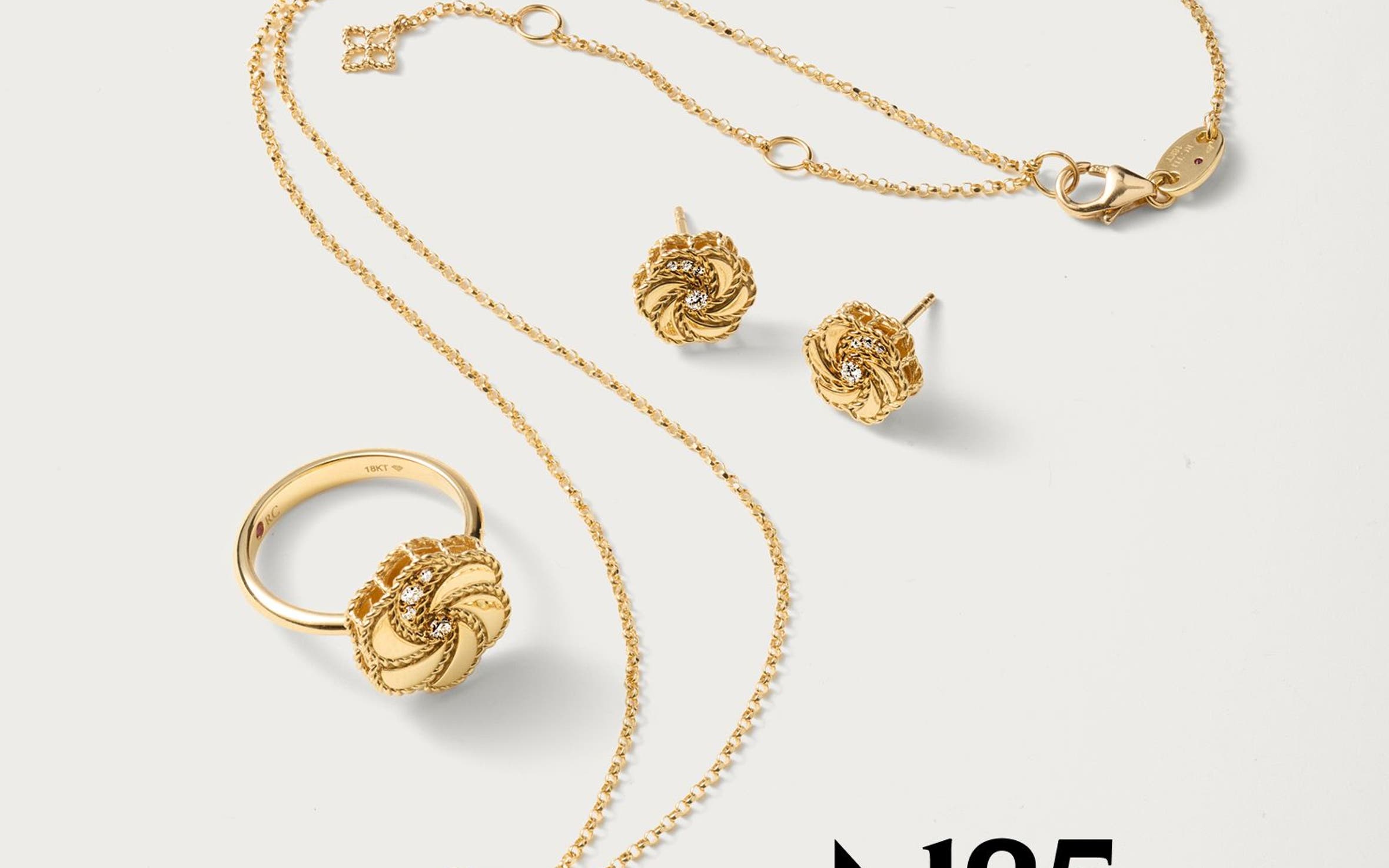 A rose shaped gold ring, necklace, and pair of earrings. 