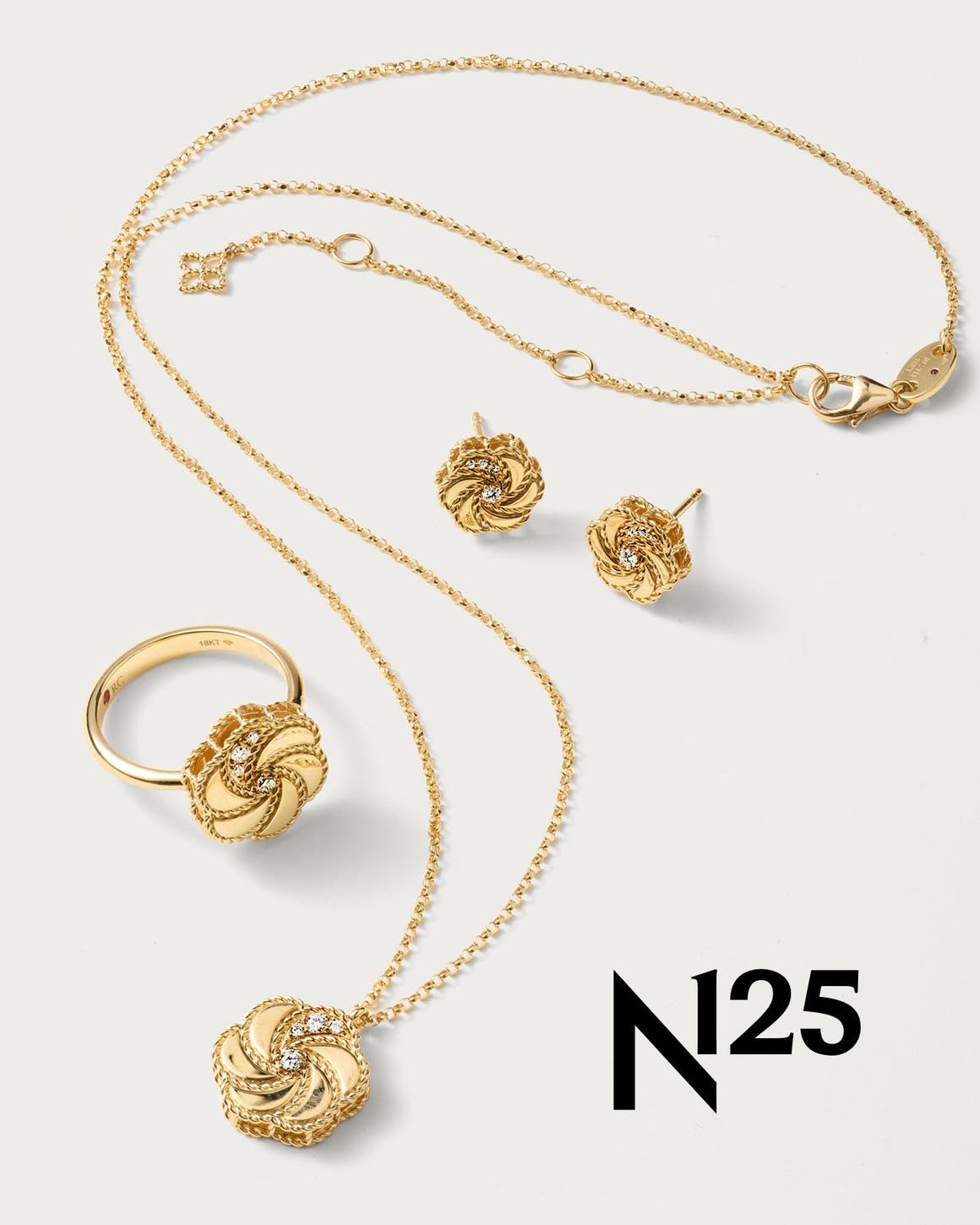 A rose shaped gold ring, necklace, and pair of earrings. 