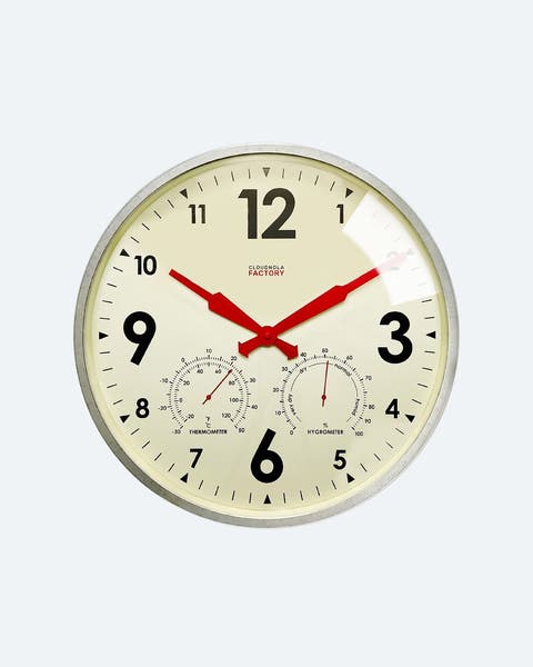A cream colored clock, with black numbers and red hands.