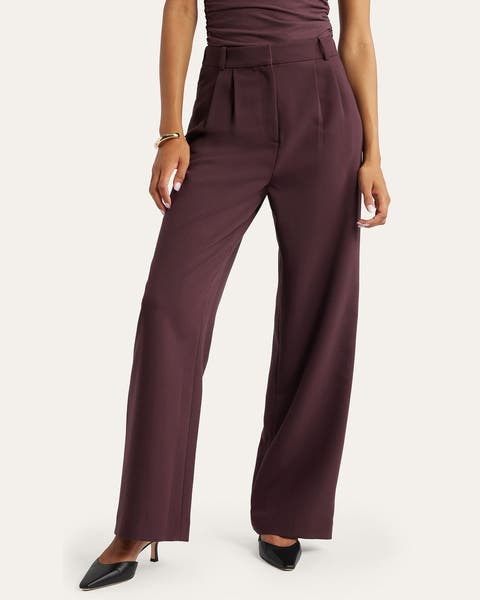 A woman wearing burgundy trouser pants.