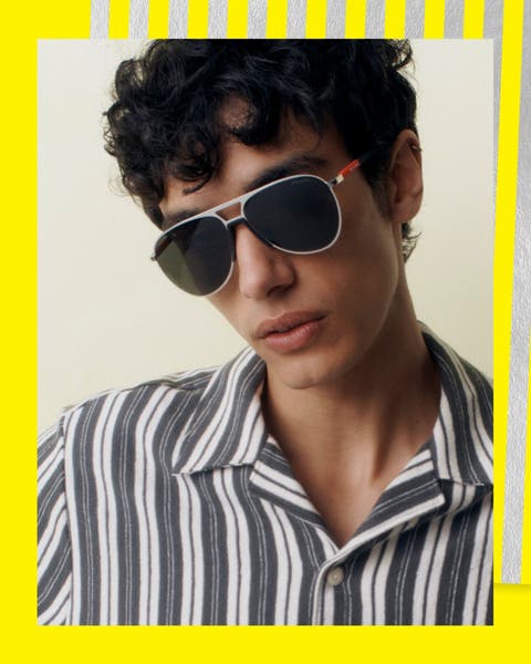 A man wearing aviator sunglasses and a striped shirt.