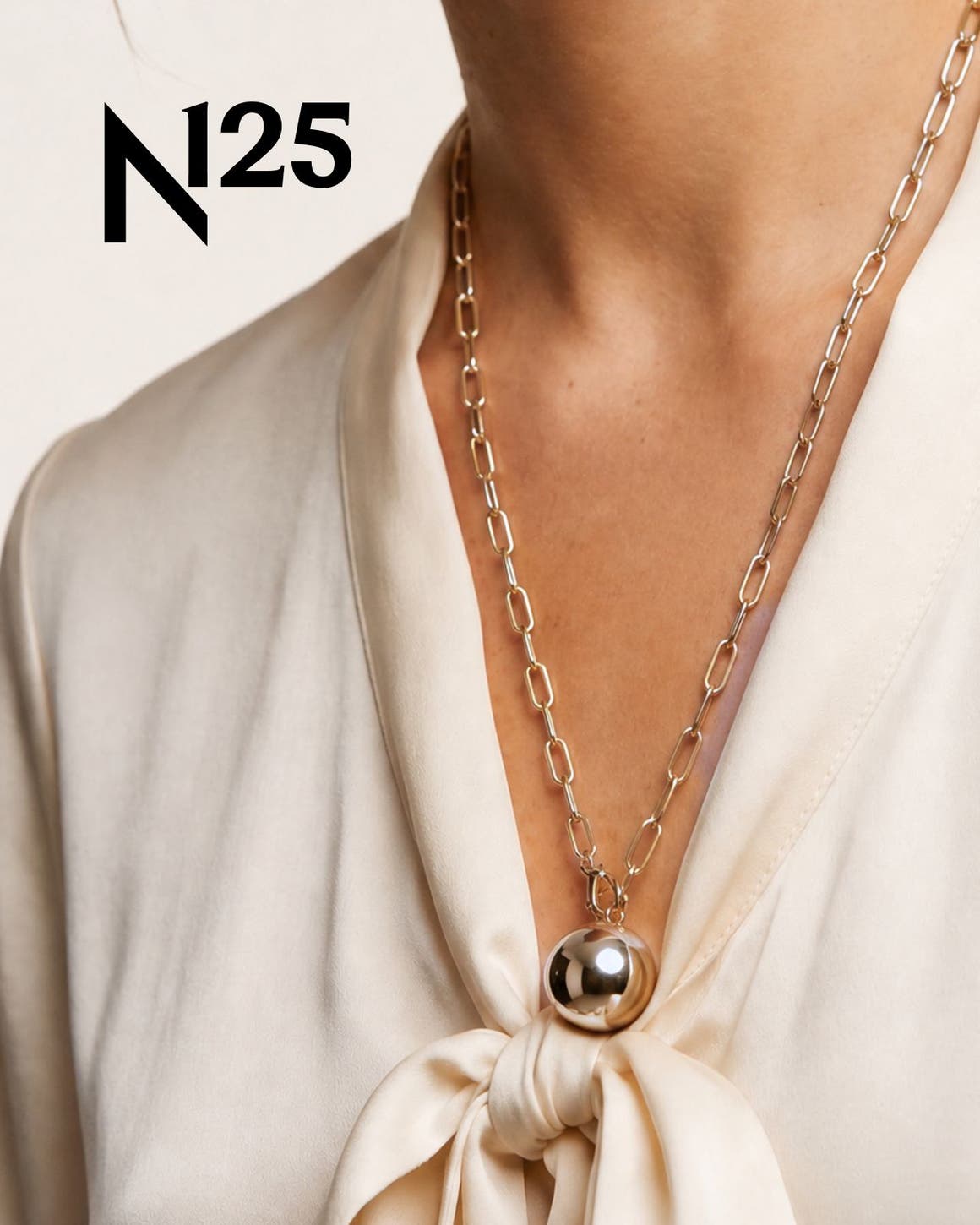 A woman wearing a gold chain necklace.