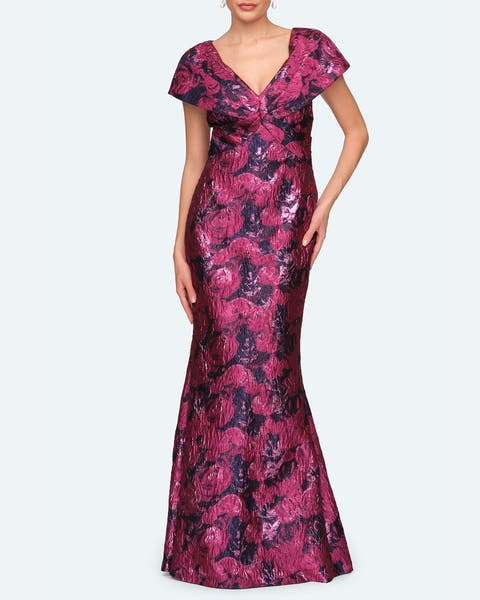 A woman wearing a dark pink floral mermaid gown.