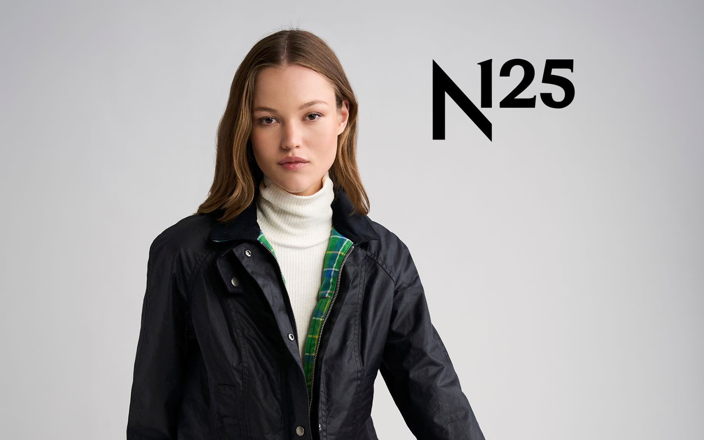 A woman wearing a blue Barbour jacket with green tartan.
