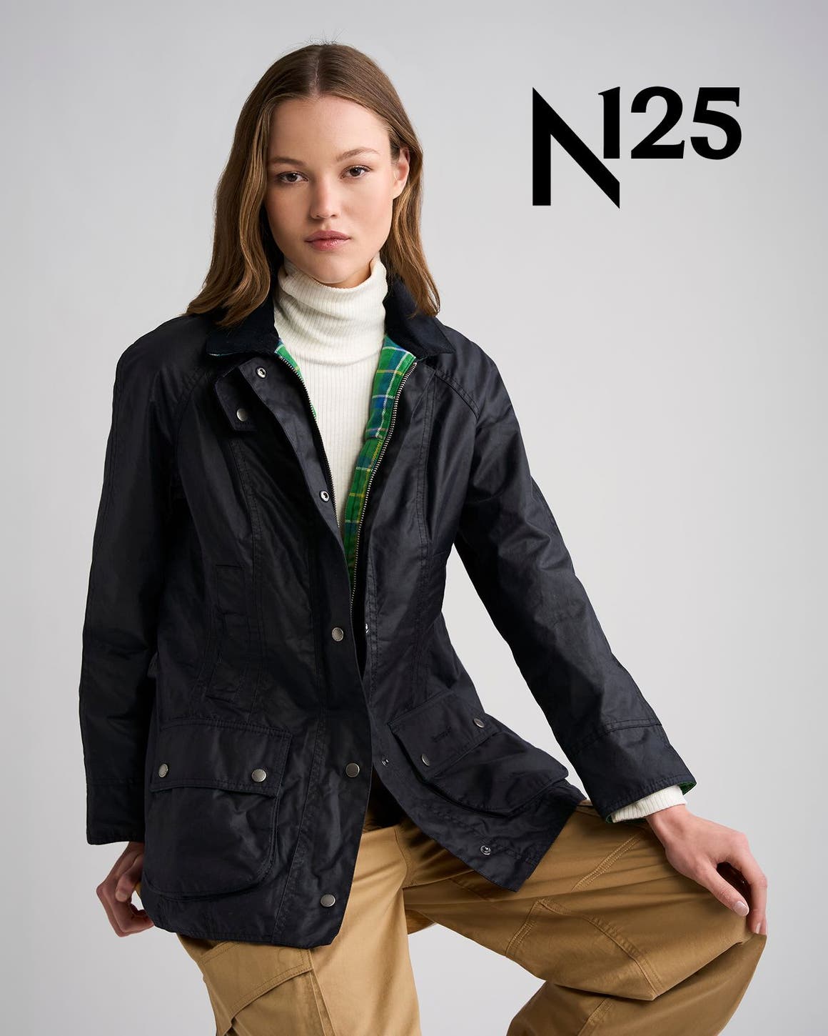 A woman wearing a blue Barbour jacket with green tartan.