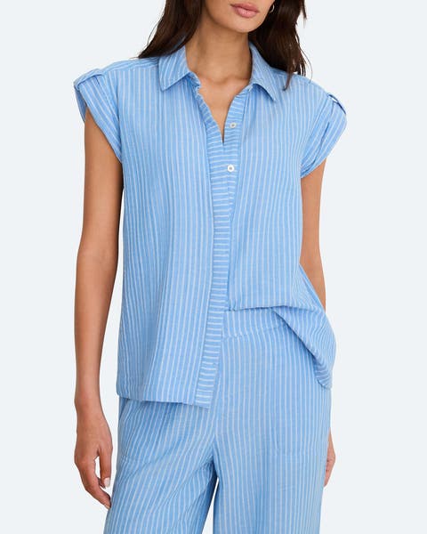 A woman wearing a blue stripe button up sleeveless shirt.