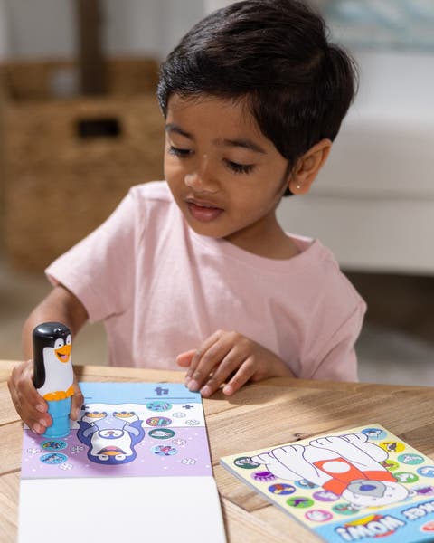 Child using a Melissa & Doug penguin stamp with sticker activity pads