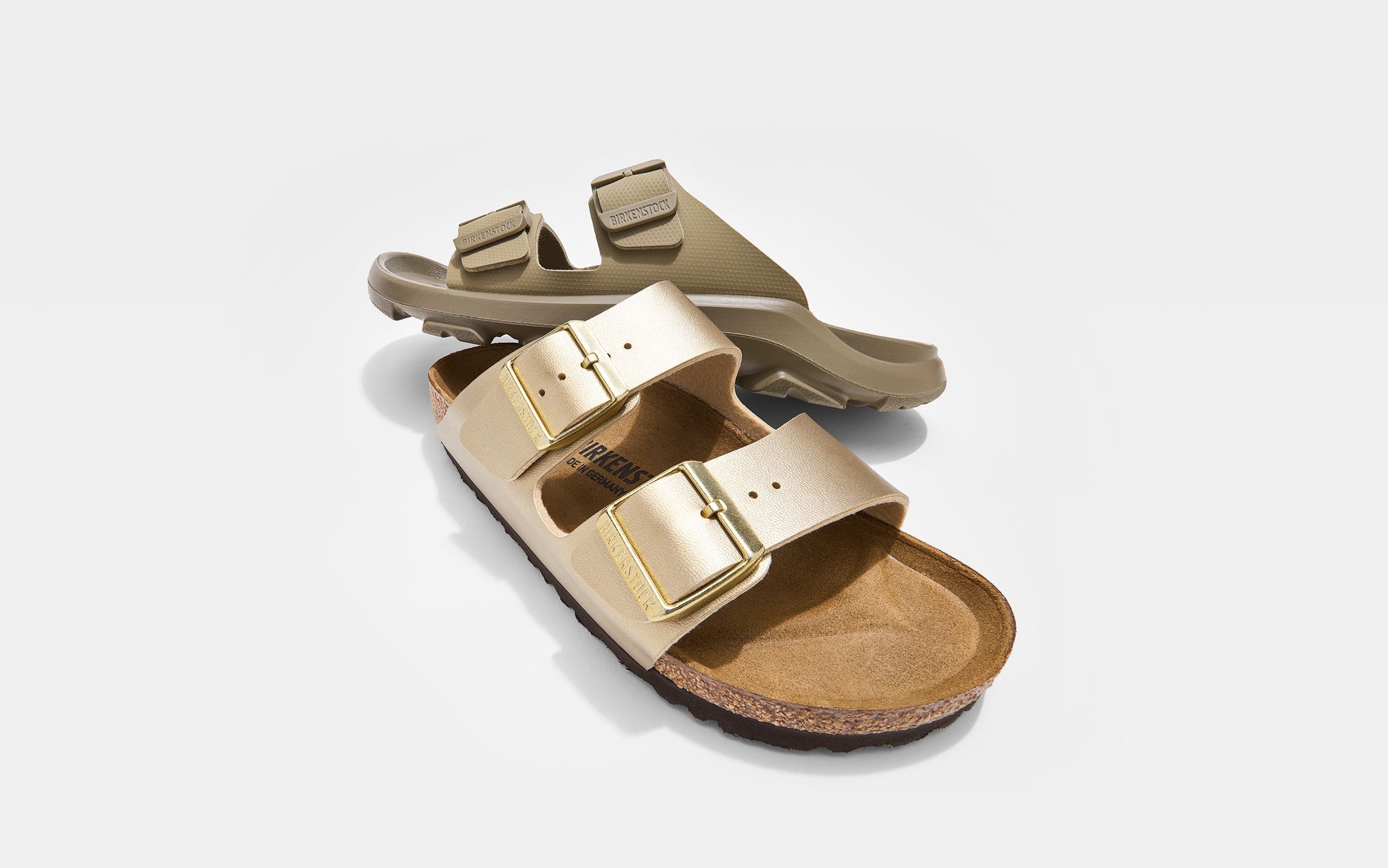 A tan Birkenstock sandal and a gold Birkenstock sandal. 