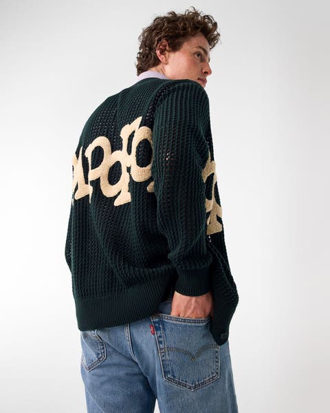 A young man wearing a blue top with jeans.