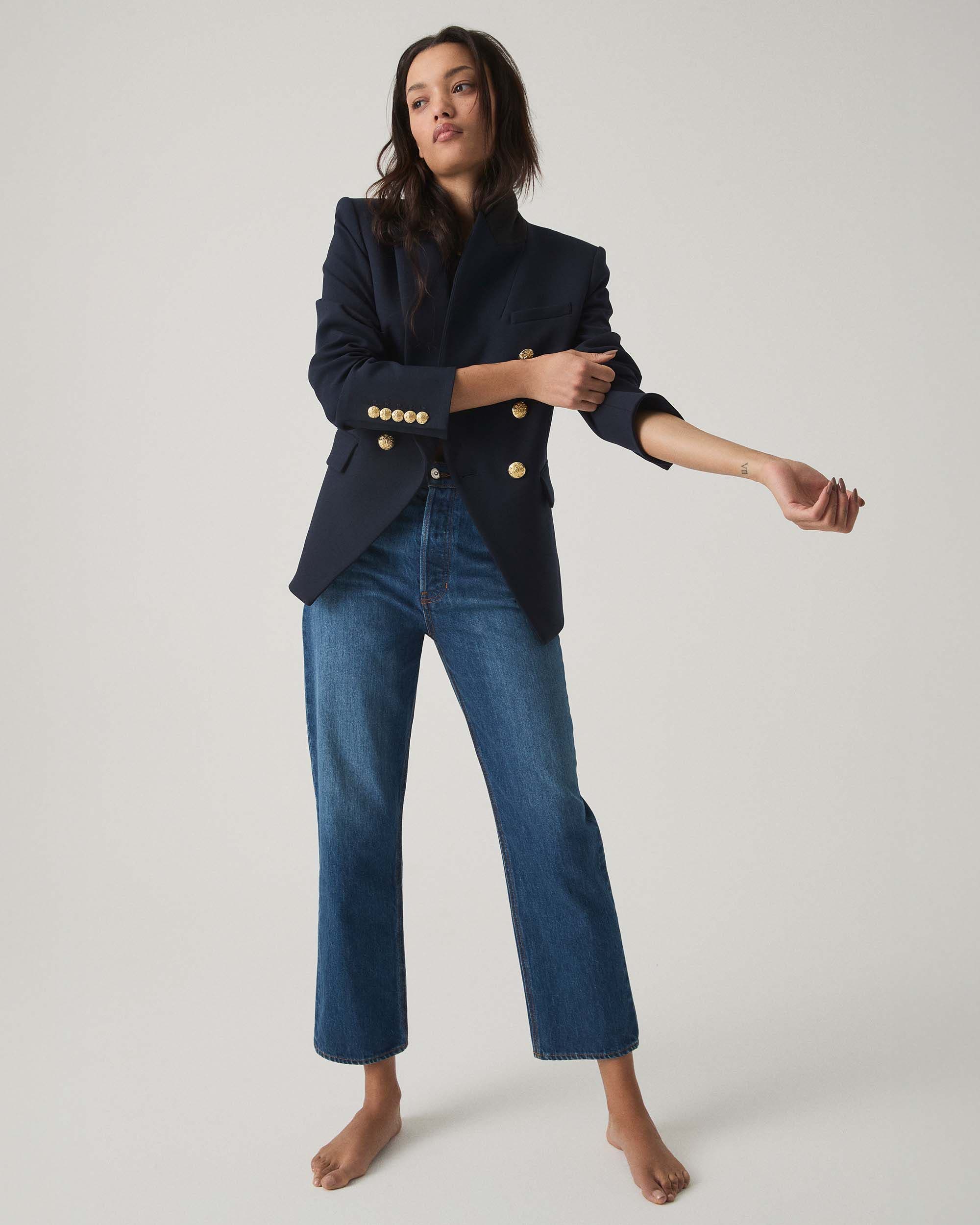 A woman wearing a navy blazer and jeans from Veronica Beard.