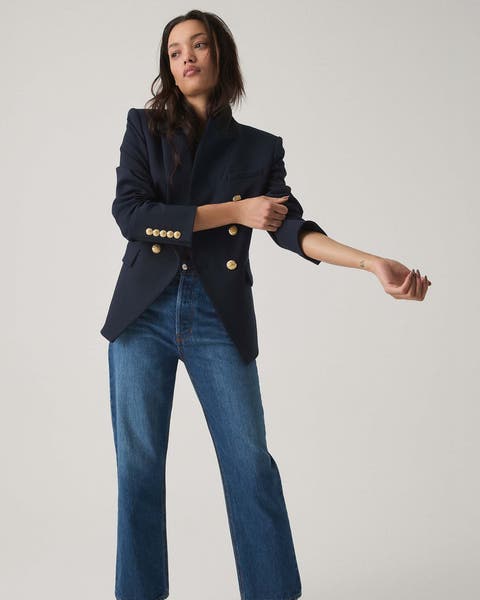 A woman wearing a navy blazer and jeans from Veronica Beard.