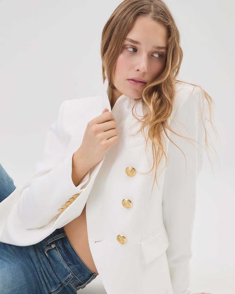 Woman wearing a white Veronica Beard blazer with jeans.