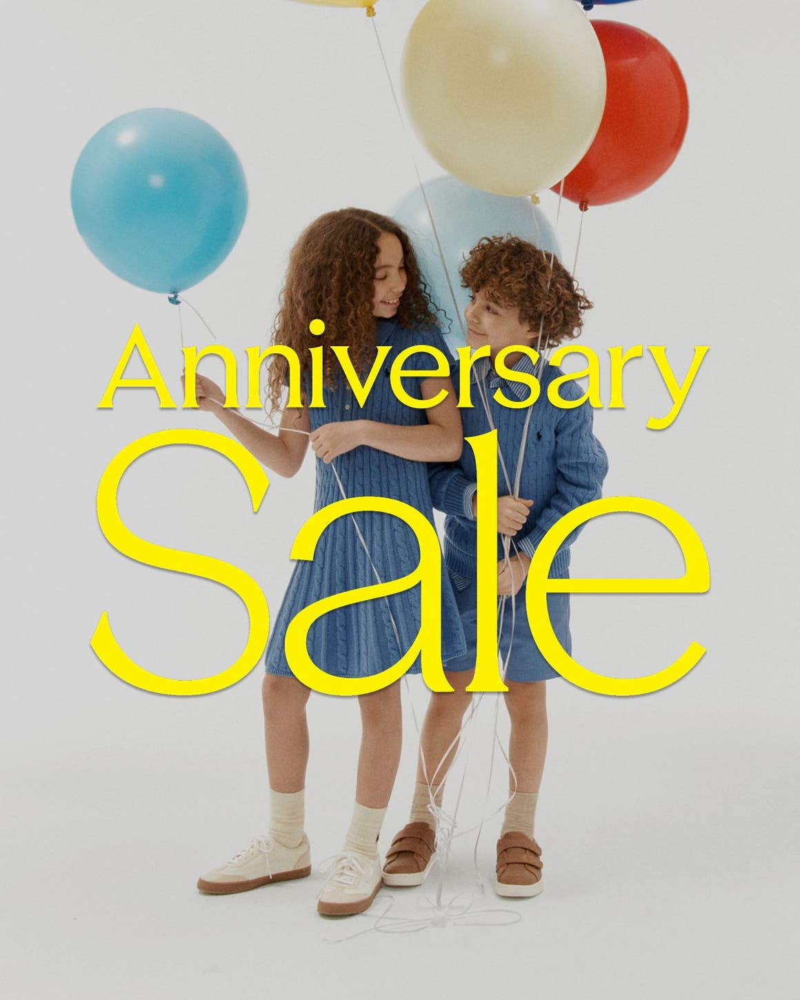Anniversary Sale: a boy and girl in sale styles holding balloons. secondary: