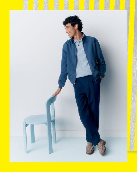 A man wearing loafers with a jacket, polo and pants.