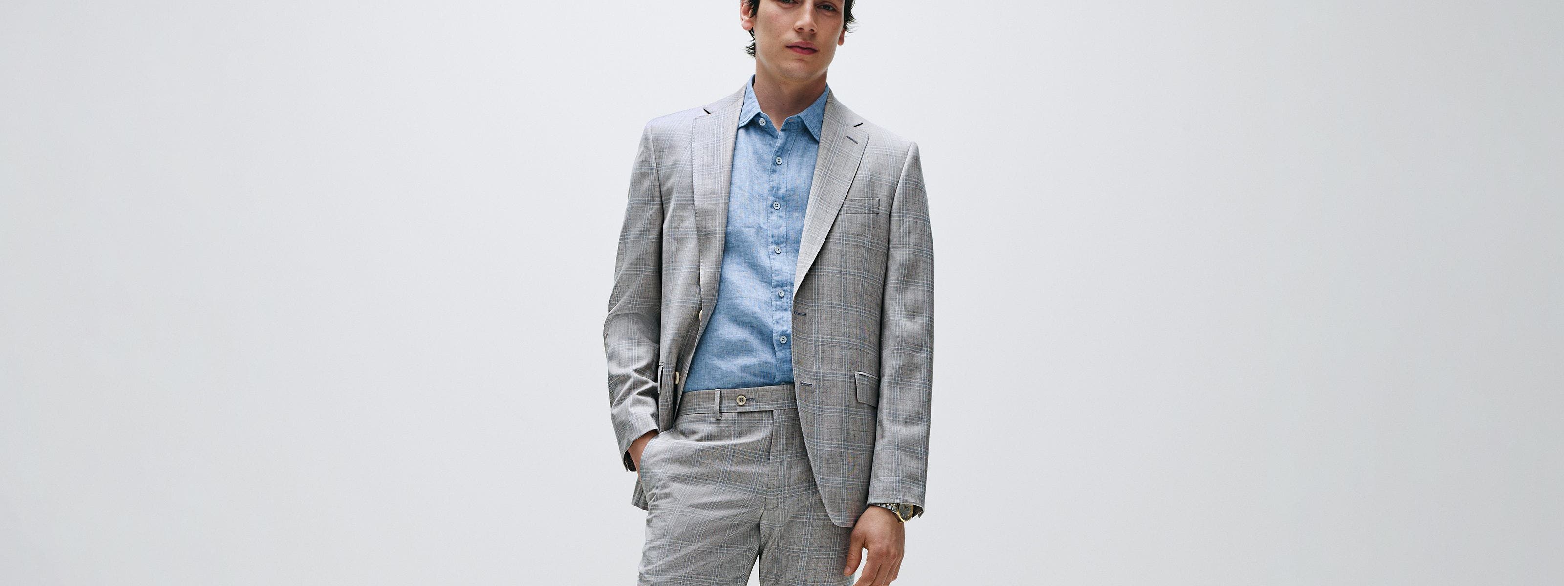 Man wearing a grey plaid suit and blue button-down.