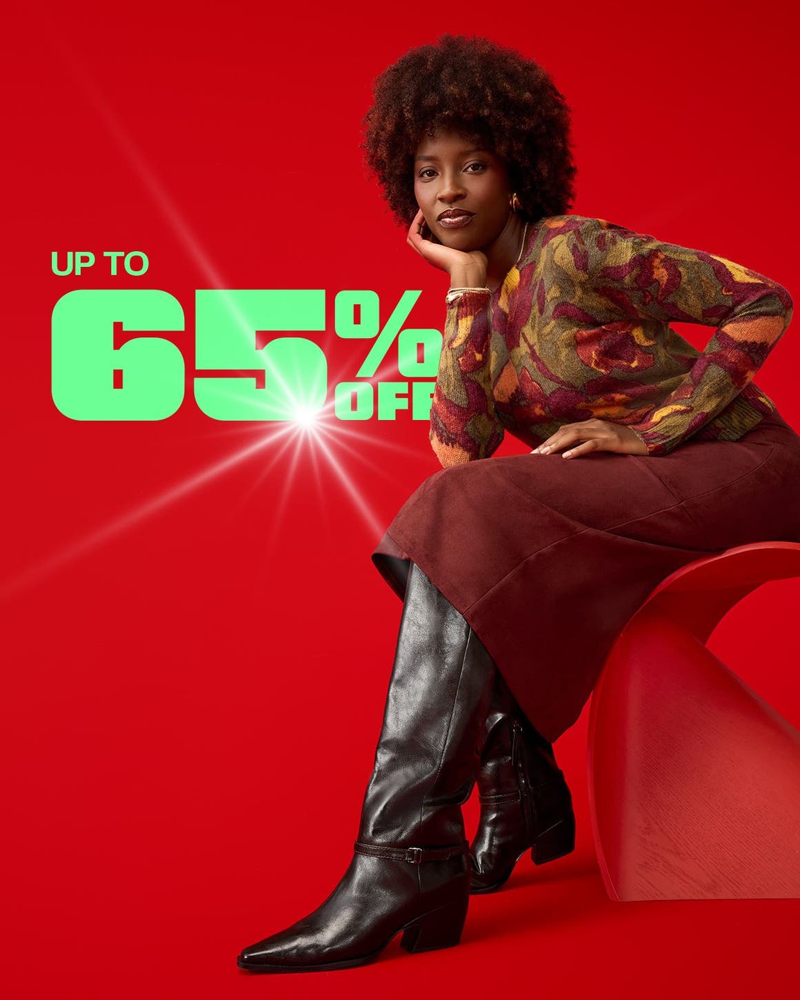 A woman wearing a sweater, skirt and boots.