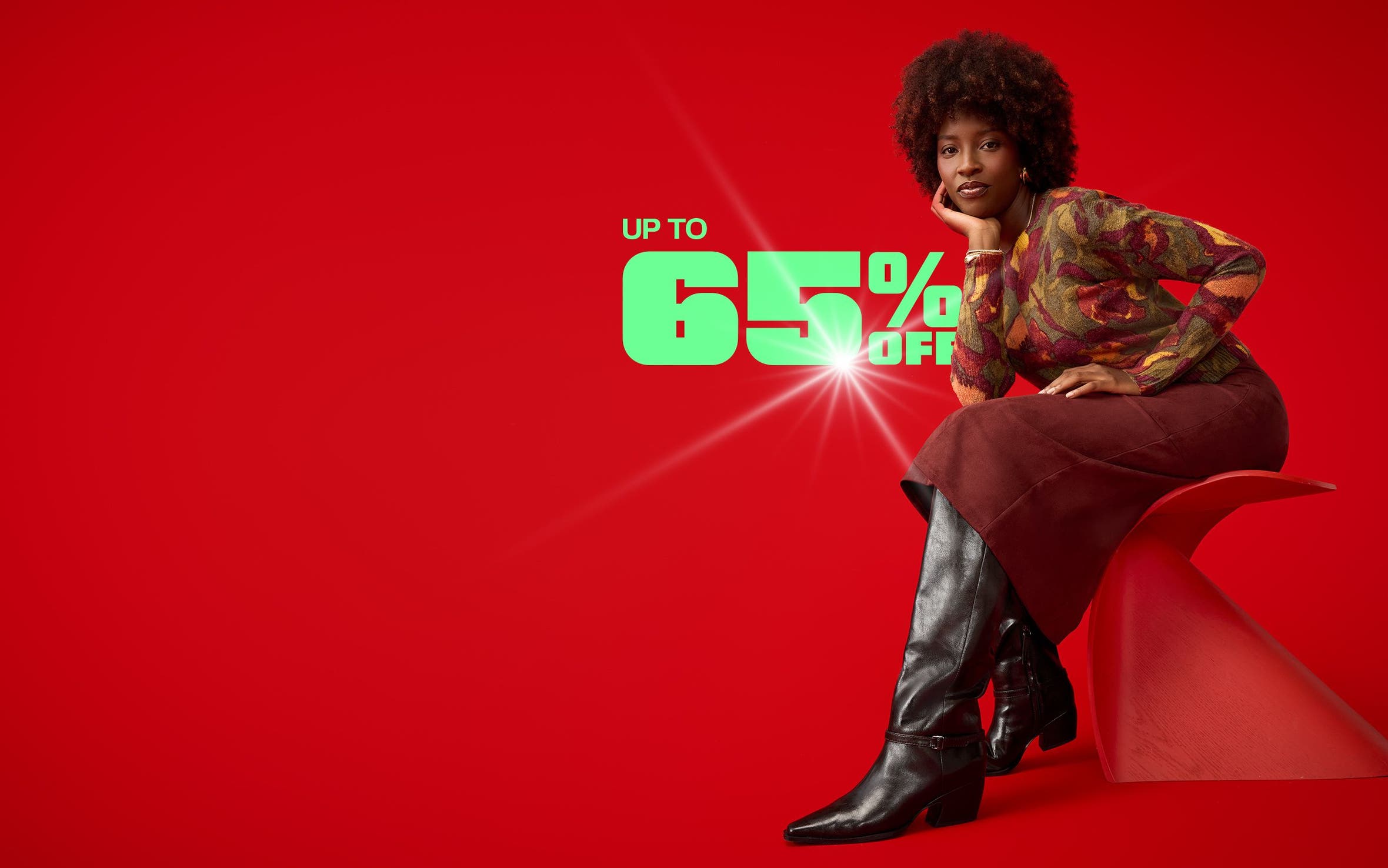 A woman wearing a sweater, skirt and boots.